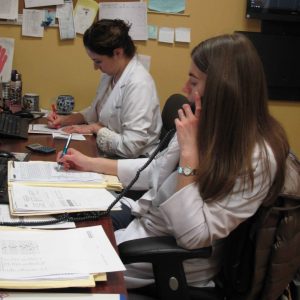 two women writing and talking on the phone